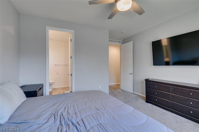 bedroom with ceiling fan, connected bathroom, and light carpet