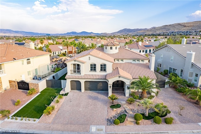 mediterranean / spanish home with a garage and a mountain view