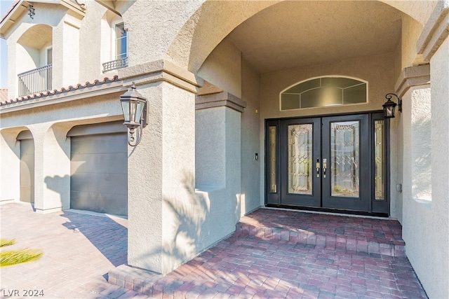 doorway to property with a garage and french doors