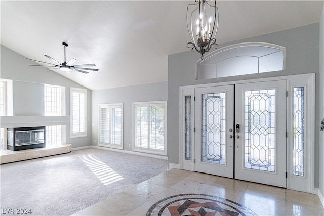 foyer entrance featuring light colored carpet, vaulted ceiling, ceiling fan with notable chandelier, and french doors