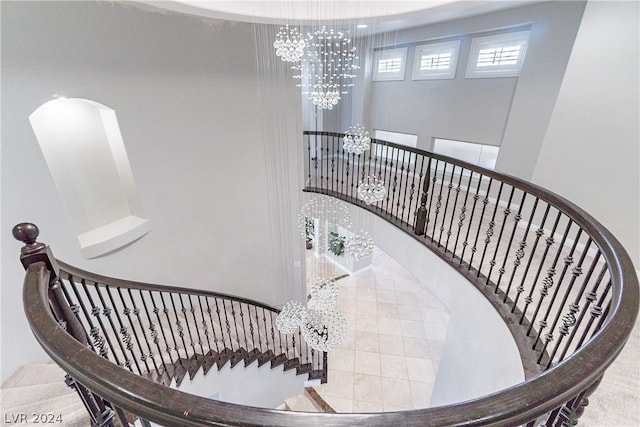 staircase with an inviting chandelier