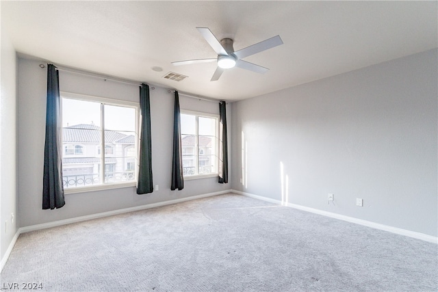 spare room with ceiling fan and light carpet