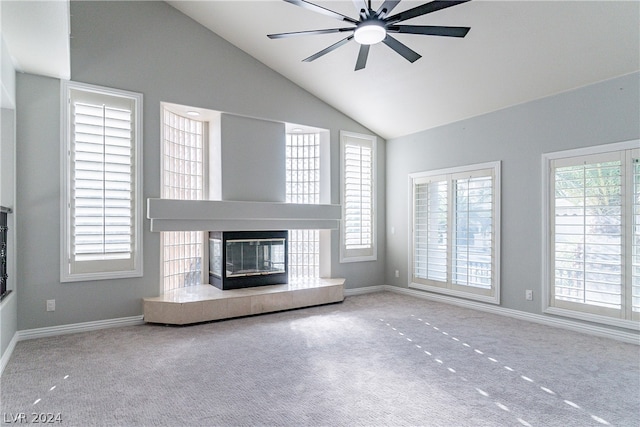 unfurnished living room featuring carpet flooring, ceiling fan, high vaulted ceiling, and a tile fireplace