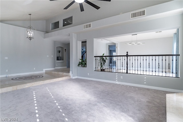 spare room featuring ceiling fan with notable chandelier, high vaulted ceiling, and carpet floors