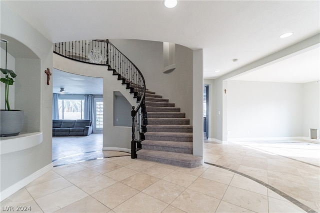 stairs with ceiling fan and tile patterned floors