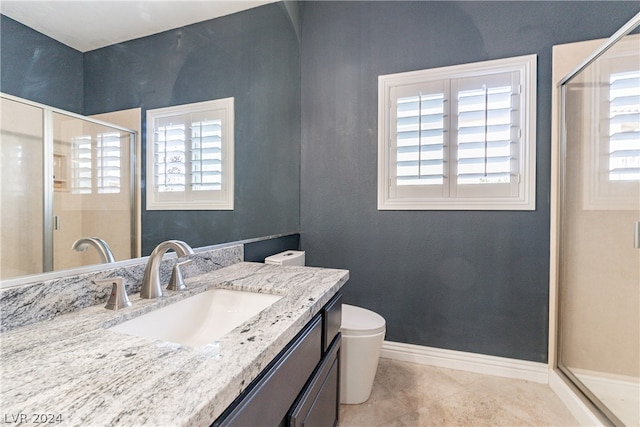 bathroom with vanity, toilet, a shower with shower door, and tile patterned flooring