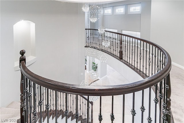 stairway featuring a chandelier