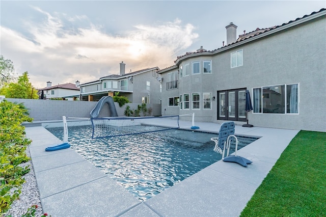 view of swimming pool with a water slide and a patio