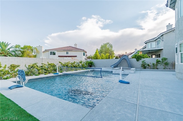 view of swimming pool featuring a water slide, a patio, and pool water feature