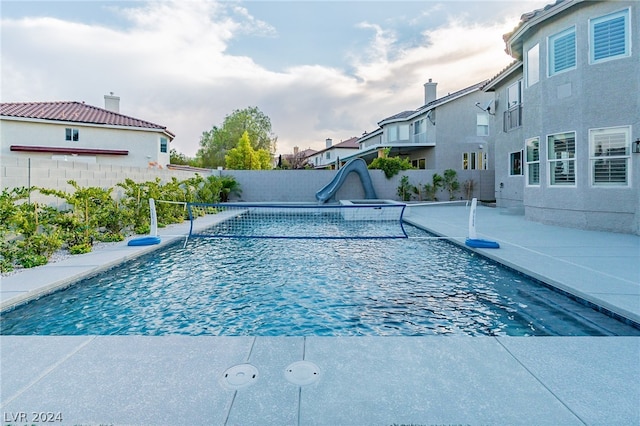 view of swimming pool featuring a water slide and a patio area