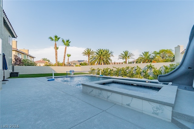 view of swimming pool with a water slide, pool water feature, an in ground hot tub, and a patio area