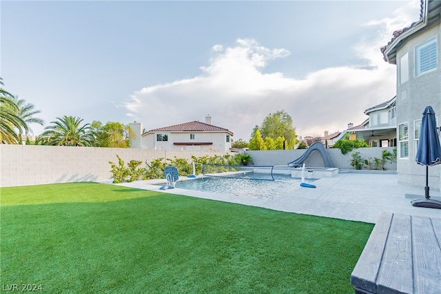 view of swimming pool featuring a water slide, a yard, and a patio