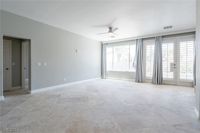 empty room with ceiling fan and french doors