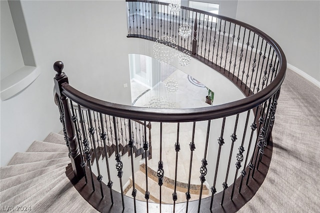 stairway featuring carpet flooring and an inviting chandelier