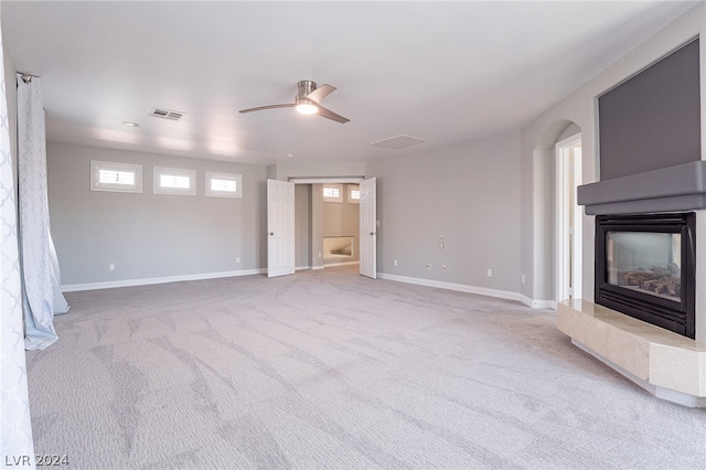 unfurnished living room with ceiling fan and light carpet