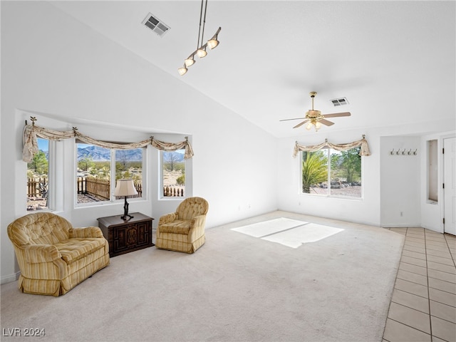 living area with ceiling fan, plenty of natural light, high vaulted ceiling, and carpet floors