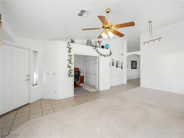 unfurnished living room featuring vaulted ceiling, ceiling fan, and light colored carpet