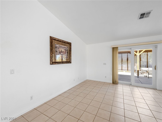 unfurnished room featuring vaulted ceiling and light tile patterned flooring