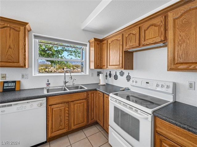 kitchen featuring light tile patterned flooring, sink, and white appliances