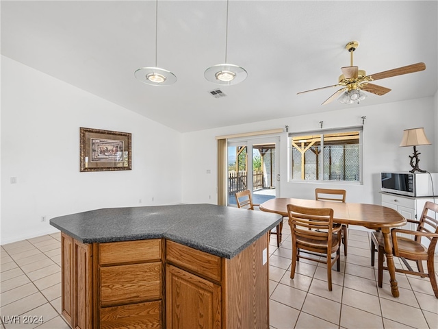 kitchen featuring ceiling fan, light tile patterned floors, lofted ceiling, and a kitchen island