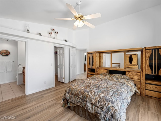 bedroom with ceiling fan, ensuite bath, and light wood-type flooring