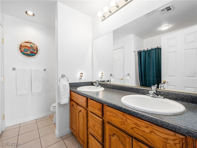 bathroom featuring toilet, tile patterned flooring, and vanity