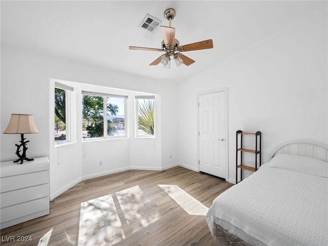 bedroom featuring ceiling fan, vaulted ceiling, and light wood-type flooring