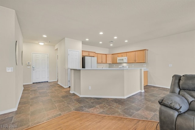 kitchen with light brown cabinets, wood-type flooring, and white appliances