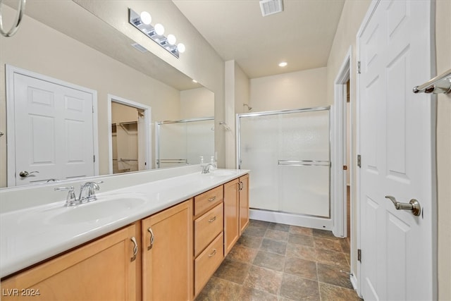 bathroom featuring double vanity, tile patterned flooring, and a shower with shower door