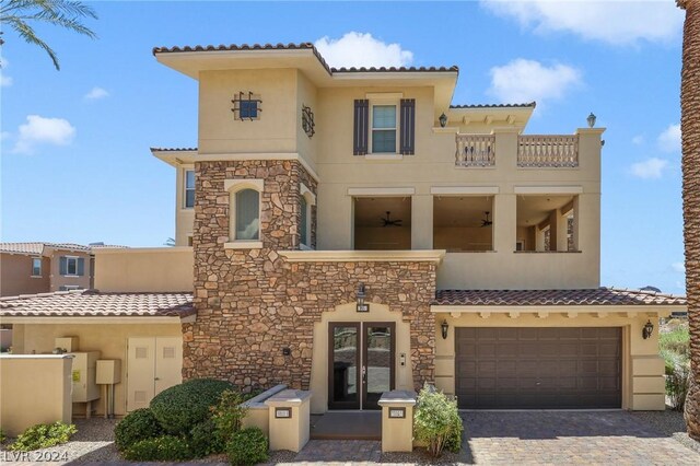 mediterranean / spanish house featuring a garage and a balcony