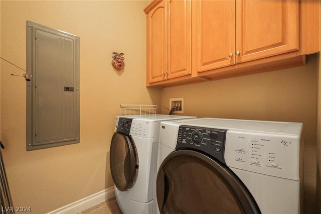 laundry room featuring cabinets, electric panel, and washer and clothes dryer