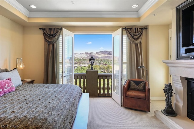 bedroom featuring light colored carpet, ornamental molding, a raised ceiling, and a mountain view