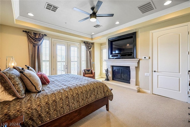 bedroom with access to exterior, crown molding, light colored carpet, and a raised ceiling