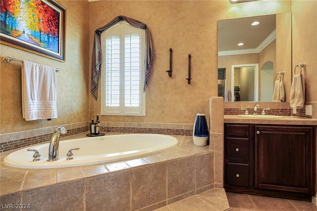 bathroom with a relaxing tiled tub, vanity, a wealth of natural light, and ornamental molding