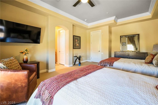 bedroom featuring ceiling fan, light colored carpet, ornamental molding, and a raised ceiling