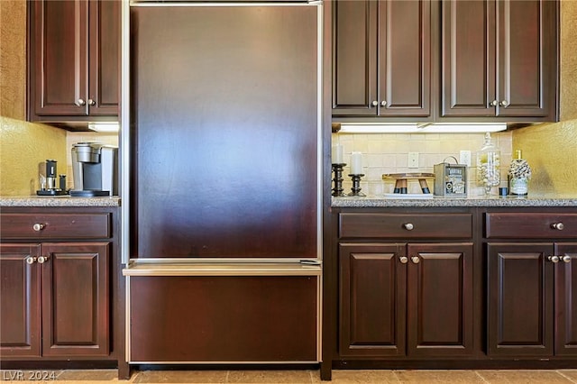 kitchen with paneled refrigerator and decorative backsplash