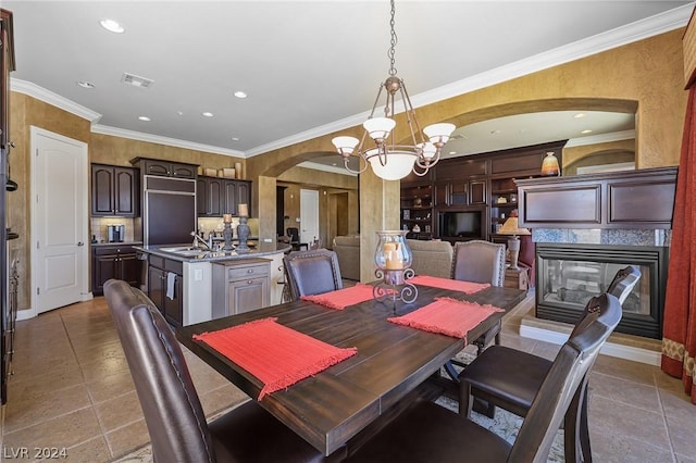 dining room featuring ornamental molding, a multi sided fireplace, a notable chandelier, and tile patterned floors