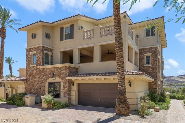 mediterranean / spanish house featuring a balcony, a garage, and ceiling fan