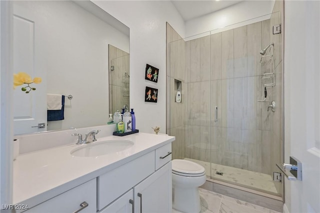 bathroom featuring vanity, toilet, and a shower with shower door