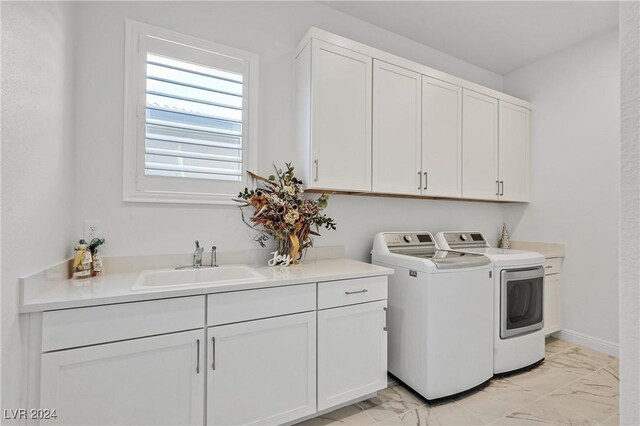 laundry room featuring washer and dryer, sink, and cabinets