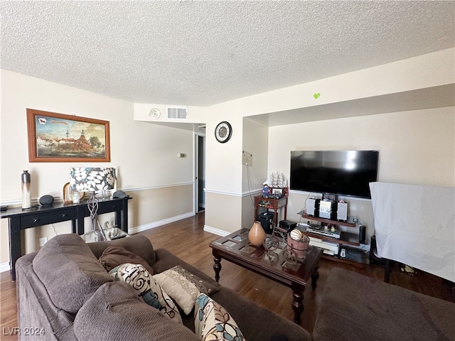 living room featuring a textured ceiling and dark wood-type flooring