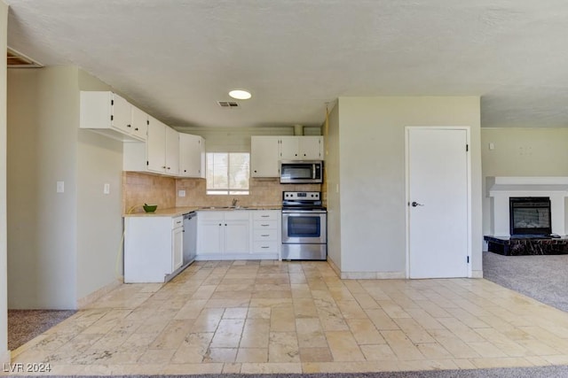 kitchen with tasteful backsplash, light countertops, visible vents, appliances with stainless steel finishes, and a sink