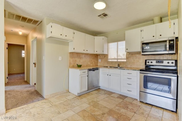 kitchen featuring stainless steel appliances, backsplash, visible vents, and white cabinetry