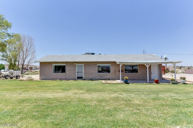 back of property with a lawn and brick siding