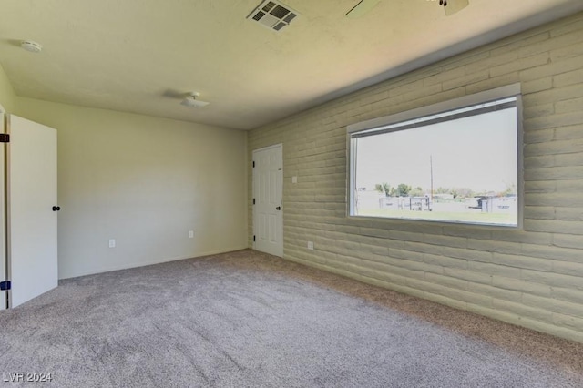 carpeted empty room featuring visible vents