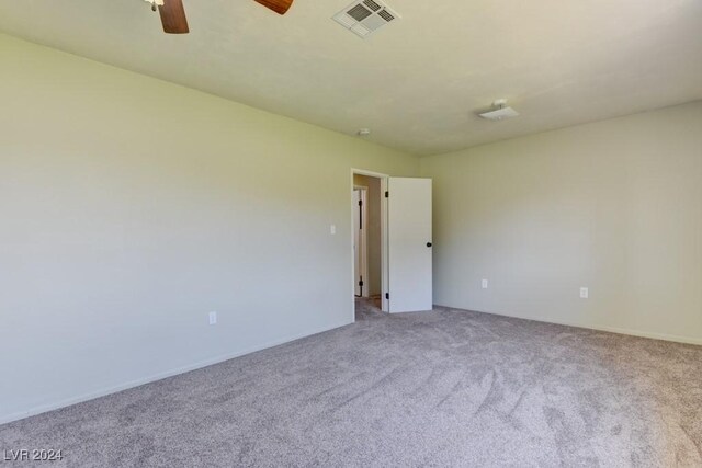 carpeted empty room featuring visible vents and a ceiling fan