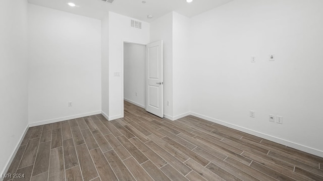 empty room with recessed lighting, visible vents, baseboards, and dark wood-type flooring