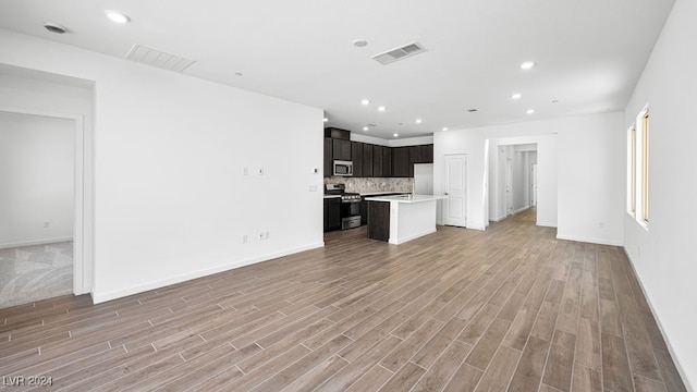 unfurnished living room featuring visible vents, recessed lighting, light wood-style flooring, and baseboards