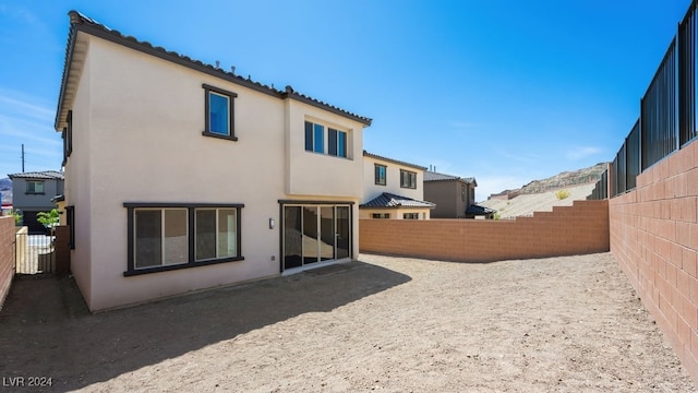 back of property with stucco siding and a fenced backyard