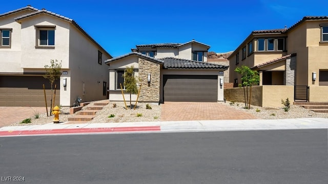 view of front of house featuring a tile roof, decorative driveway, stucco siding, and fence